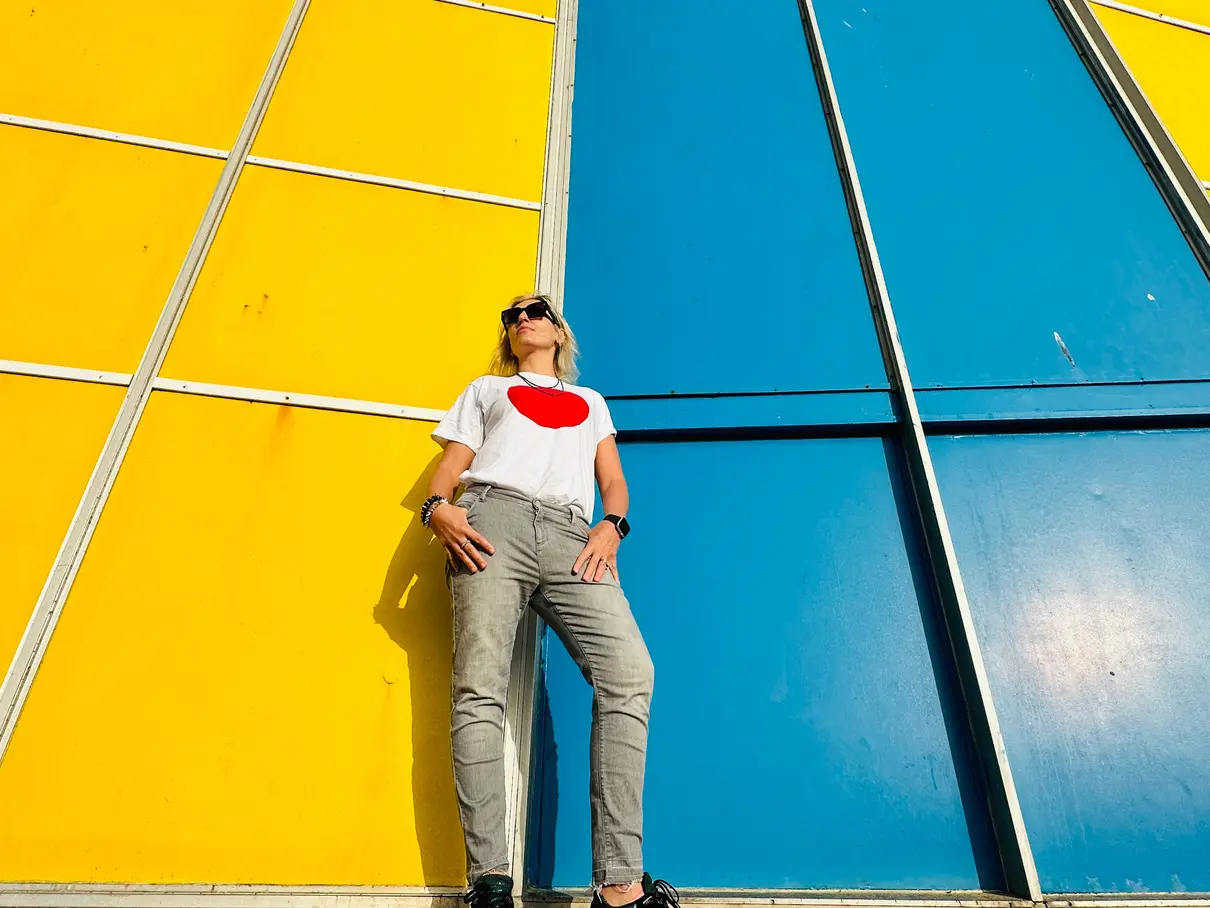 Elise standing within large yellow and blue architectural panels