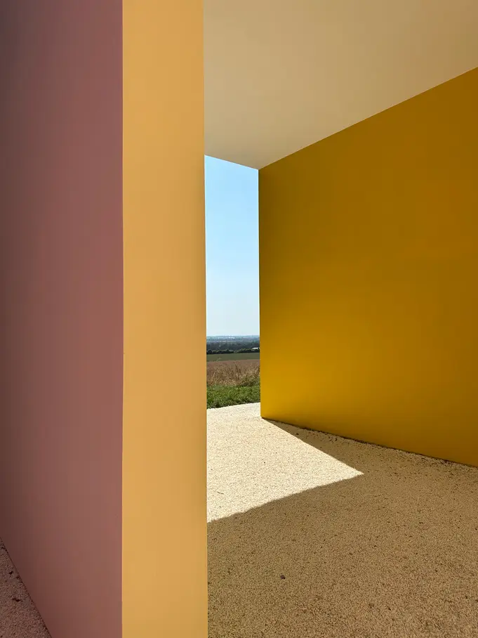 Golden architectural wall opening onto a landscape